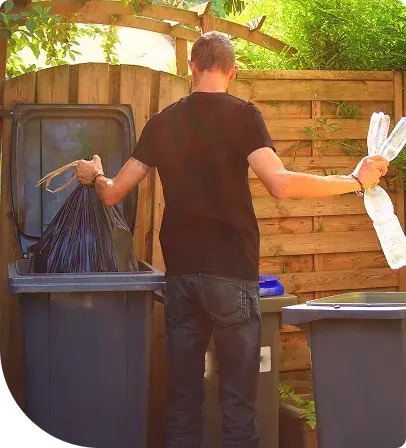 Personne de dos qui trie ses poubelles